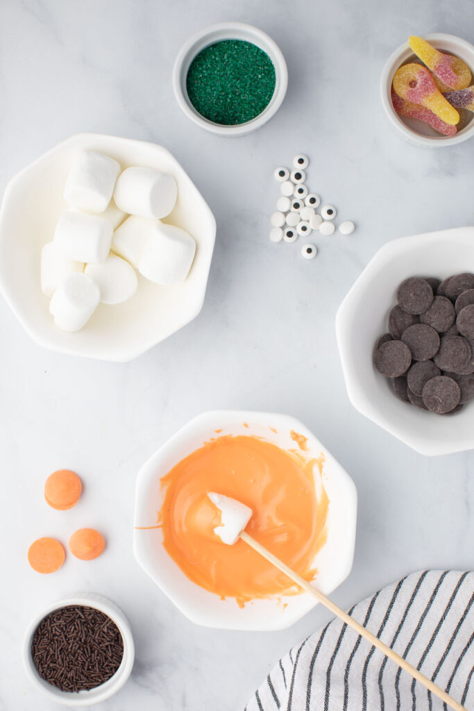 Dipping marshmellows in melted chocolate for Monster Candy Kabobs